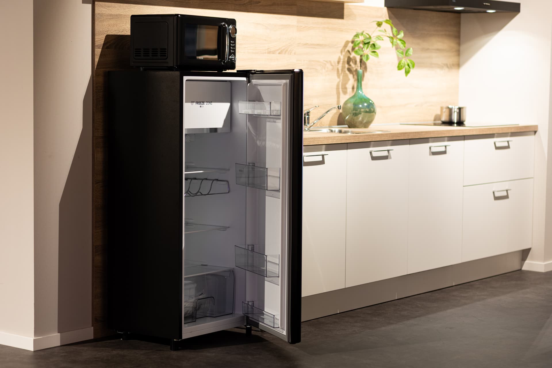 Zwarte koelkast in witte keuken
