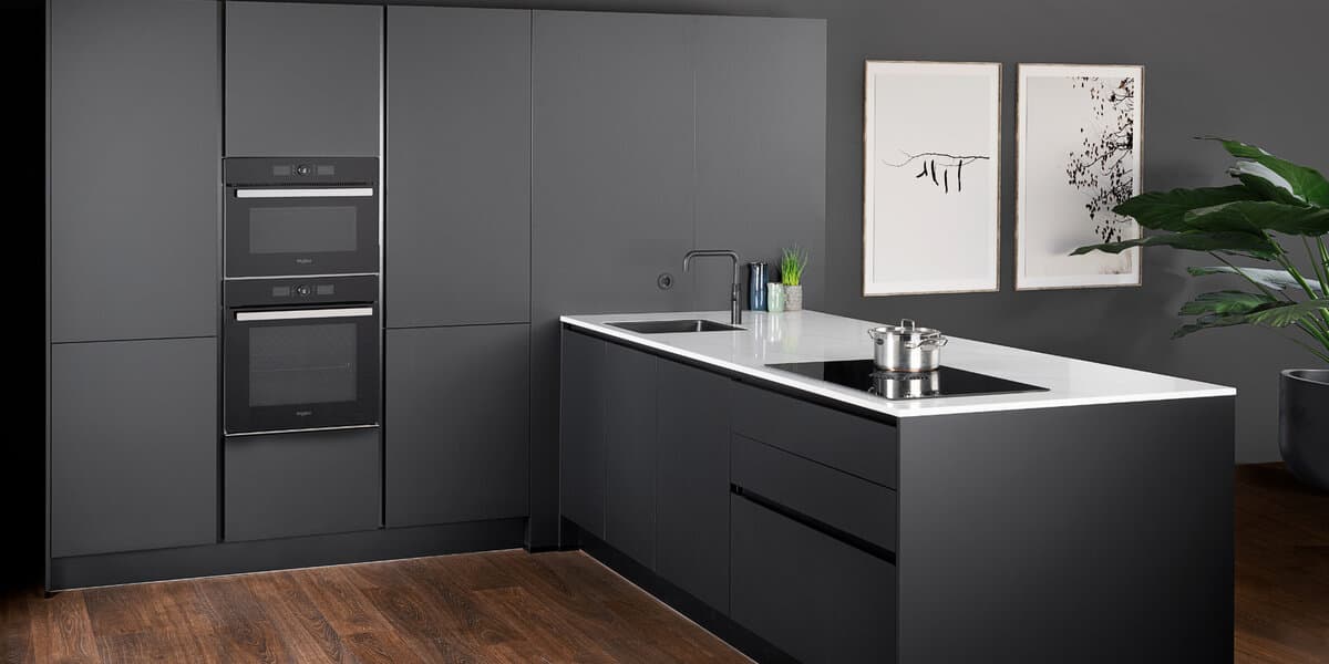 Greeploze t-keuken met zwarte kasten en wit werkblad