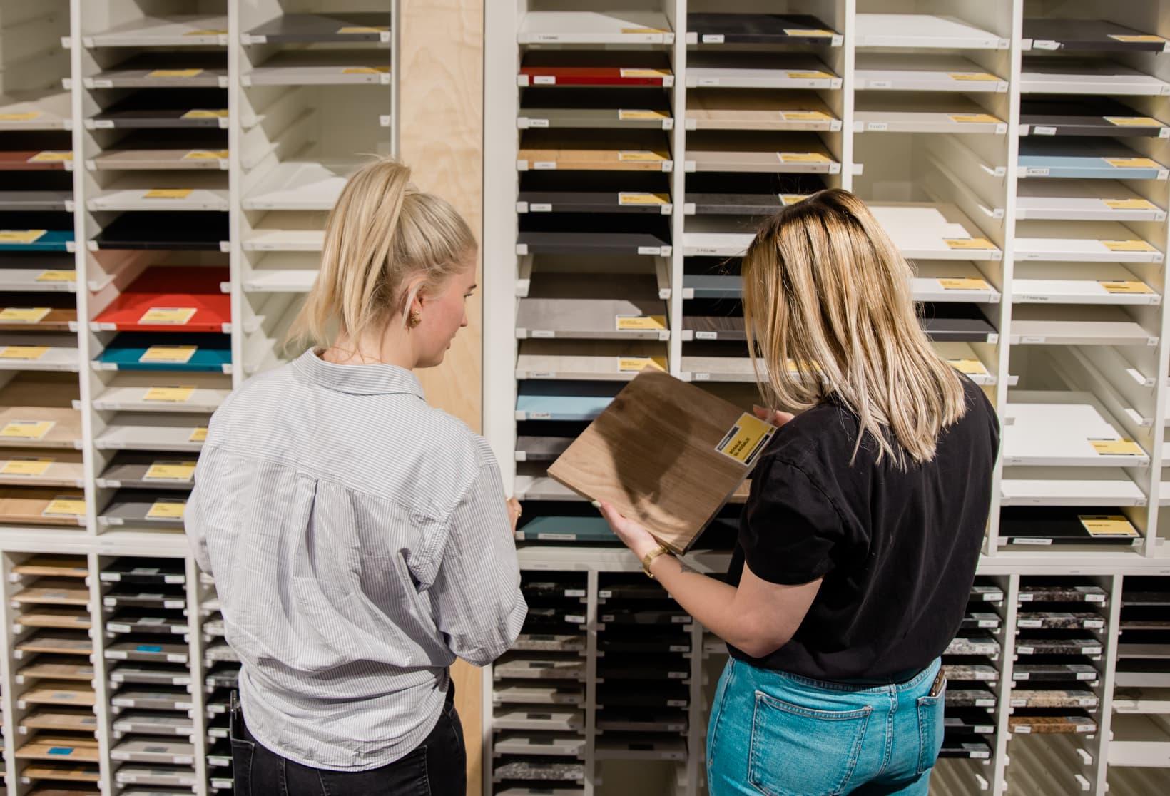 showroom-keukenfront-kiezen.jpg Twee jonge vrouwen die een keuze aan het maken zijn voor een keukenfront