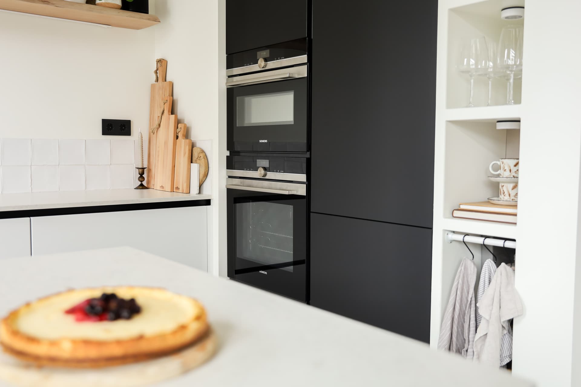 De keuken van Denise_13.jpg Witte keuken met zwarte hoge kasten en kookeiland