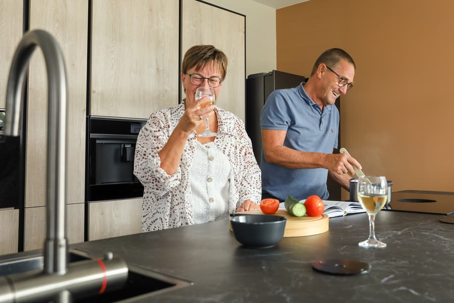 De_keuken_van_Jan en margarita00031.jpg Ouder stel die samen aan het koken zijn aan kookeiland in houten keuken