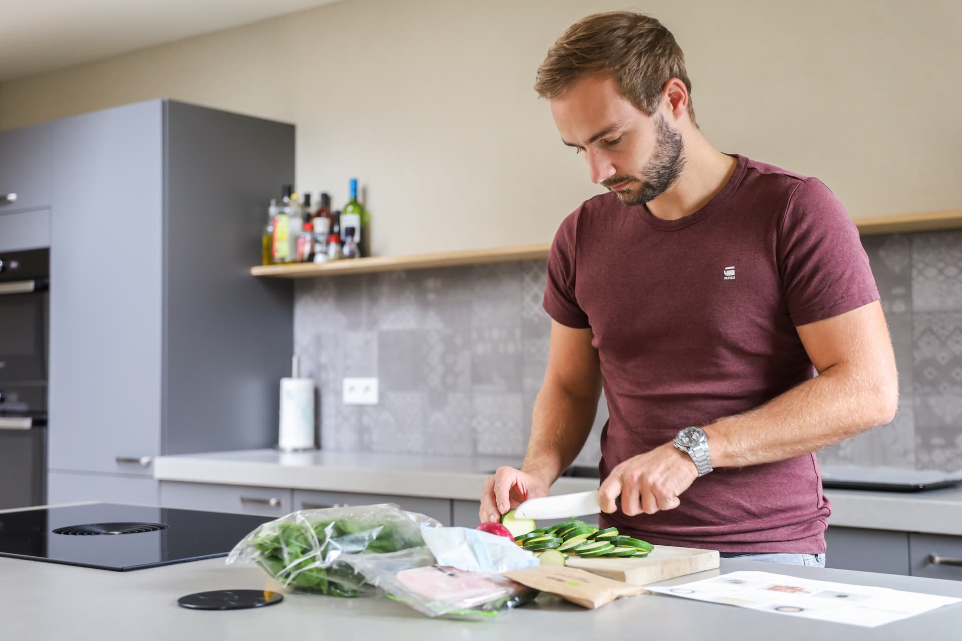 De keuken van rick en minouk_00023.jpg Jonge man die groenten aan het snijden aan kookeiland