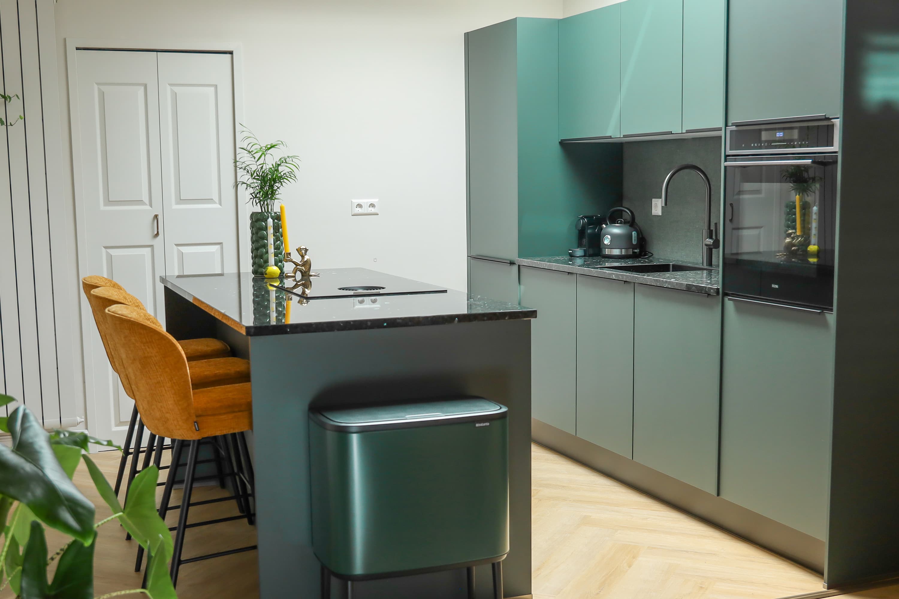 Matgroene keuken met kookeiland en bar