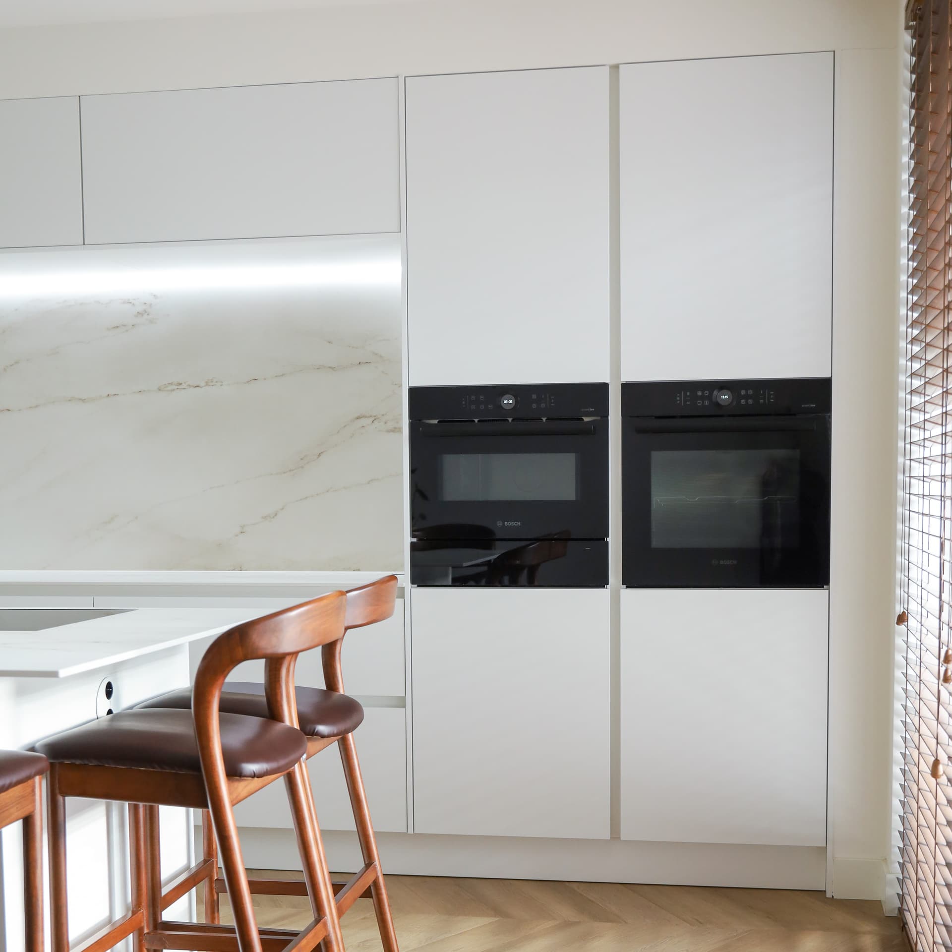binnenkijken-bij-tugba-witte-eilandkeuken-hoge-kasten.jpg Witte eilandkeuken met hoge kasten en twee ovens