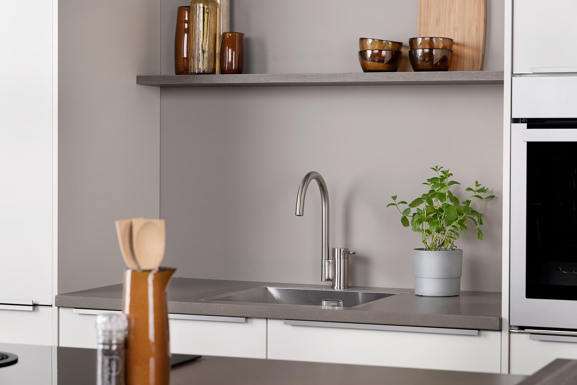keukens-met-nis-spoelbak.jpg Witte keuken met in de nis een chrome kraan en spoelbak